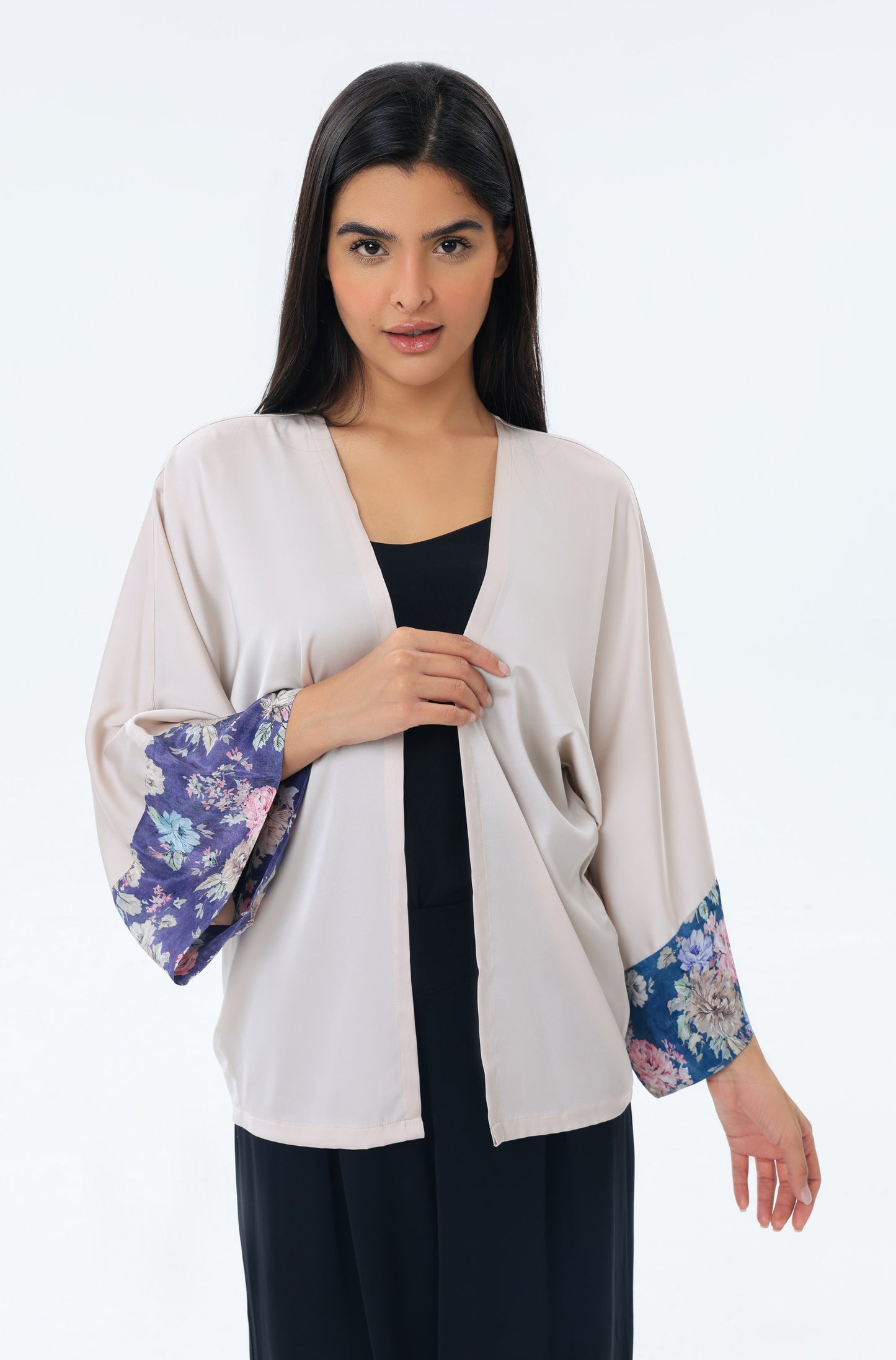Woman wearing a beige kimono with floral cuffs on a white background