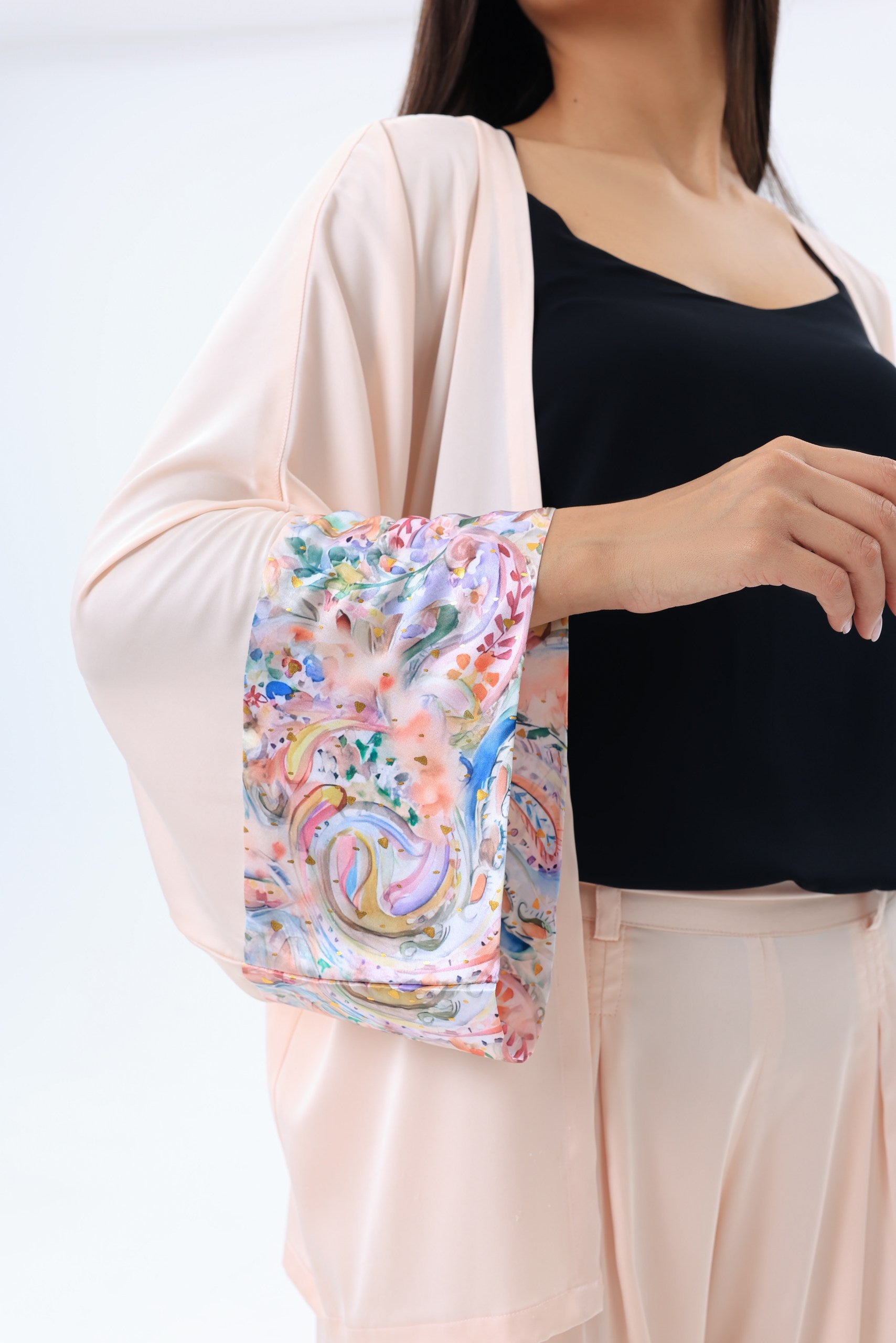 Woman wearing peach kimono with floral sleeve on a white background