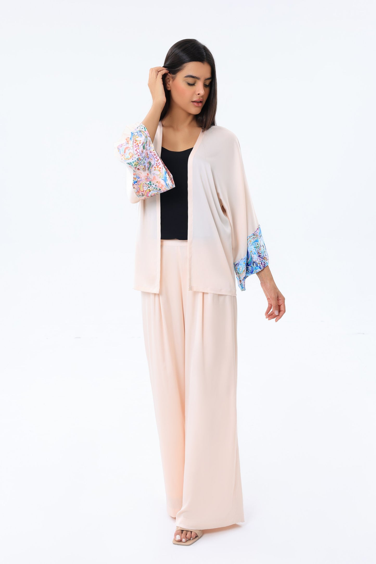 Woman wearing a beige peach outfit with a white background